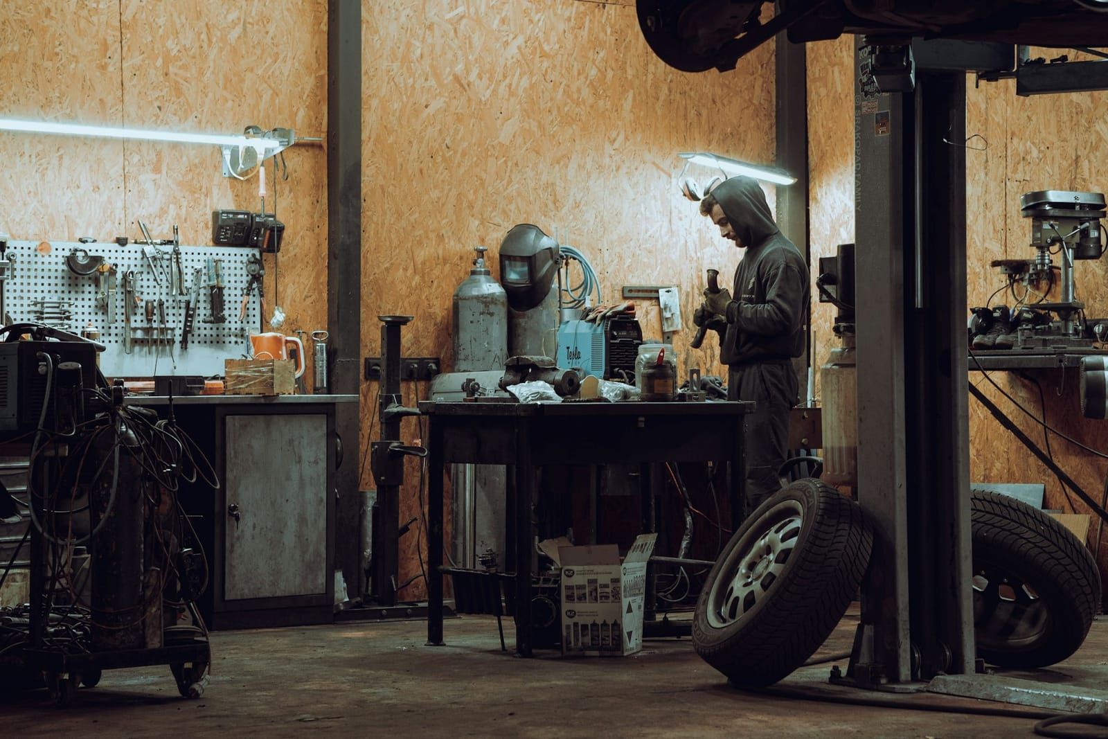 Intérieur de l’atelier : établi, outillage et voiture sur pont élévateur